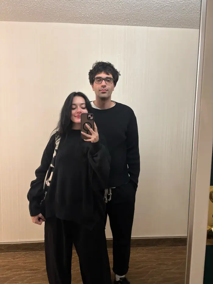 mirror photo, both of them dressed in black, thomas holding the phone