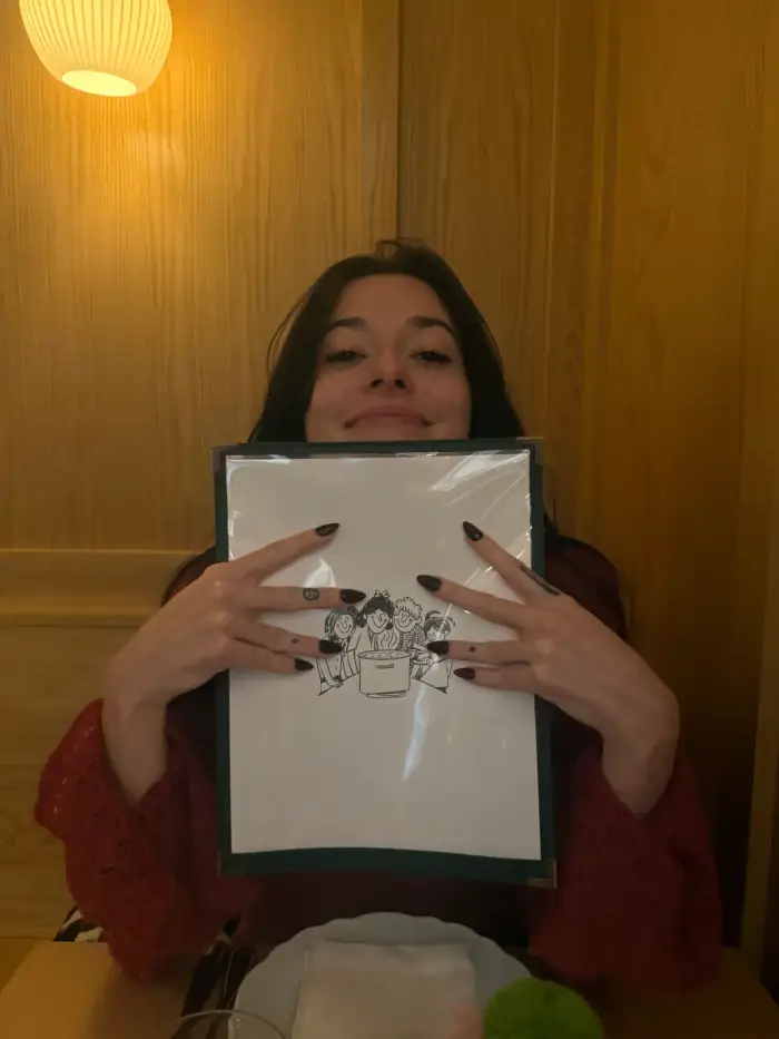 olivia holding a white gift box up under a round hallway lamp