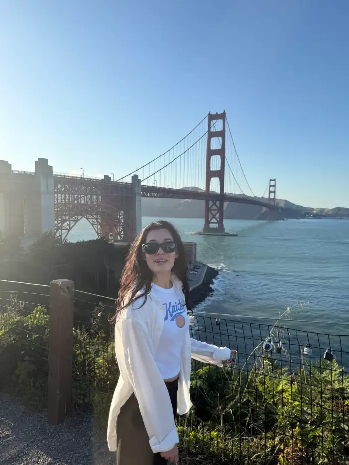 olivia in sunglasses on a hillside with the golden gate bridge behind her
