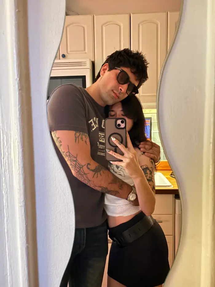 mirror photo in a kitchen doorway, thomas holding olivia from behind, sunglasses on